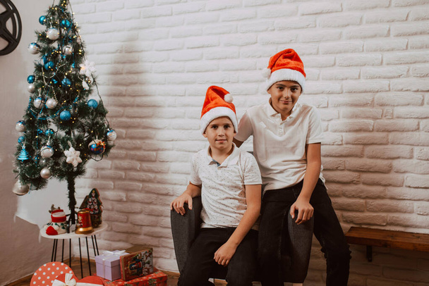 happy boys in santa hats with christmas presents - Photo, Image