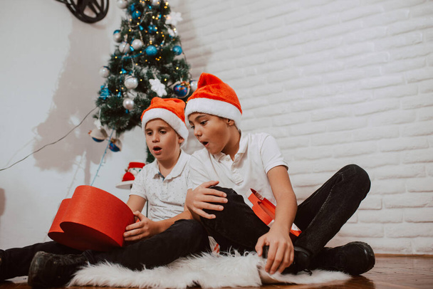 happy boys in santa hats with christmas presents - 写真・画像