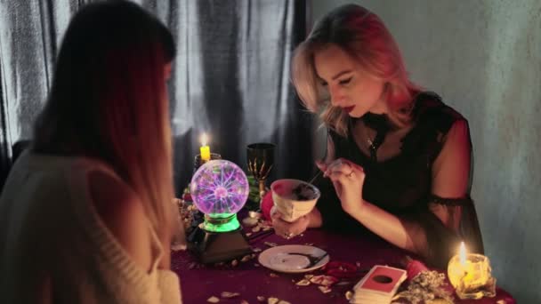 Fortune teller explains fortune on Turkish coffee to her young client - Footage, Video
