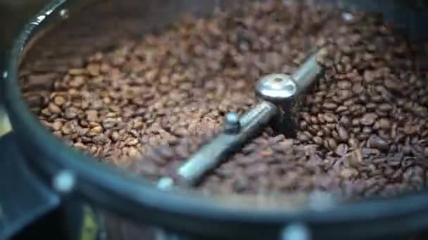 Στενή διαδικασία ψησίματος φρέσκων τηγανισμένων κόκκων καφέ. Οι επεξεργασμένοι κόκκοι καφέ αναμειγνύονται γύρω από ένα πιάτο ψύξης φούρνου - Πλάνα, βίντεο