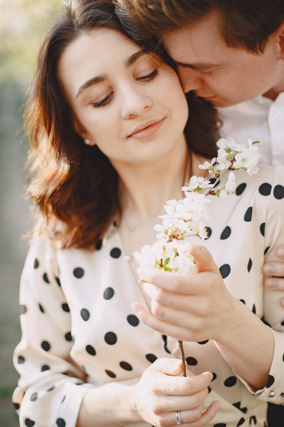 Young man and woman couple in a blooming garden - Photo, Image