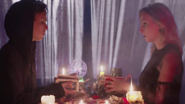 Hexe und männlicher Zauberer verteilen Karten und lesen die Zukunft und das Glück ihrer selbst - Filmmaterial, Video