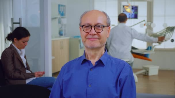 Senior man kijkt naar camera glimlachend - Video