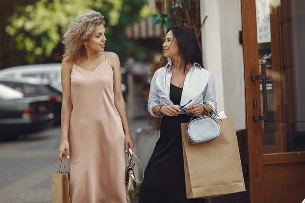 Three elegant women with shopping bags in a city - Foto, afbeelding