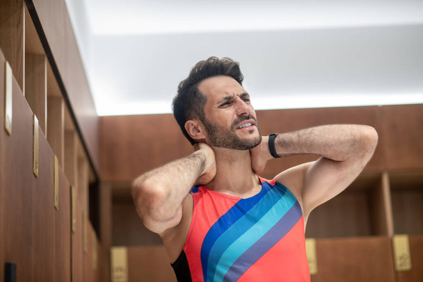 Sportsman in bright tshirt feeling unwell from pain in his neck - Valokuva, kuva