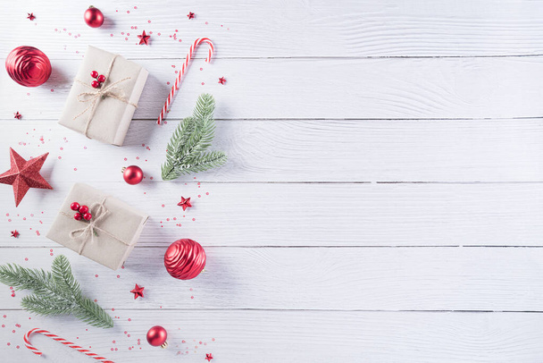 Χριστουγεννιάτικη διακόσμηση σύνθεση φόντο. Χριστουγεννιάτικο κουτί δώρου, κουκουνάρια, κλαδιά ελάτης και αστέρι σε λευκό ξύλινο φόντο. Επίπεδη lay, πάνω όψη με αντιγραφή χώρου. - Φωτογραφία, εικόνα