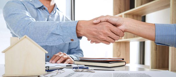 Real estate agent and customers shaking hands together celebrating finished contract after signing about home insurance and investment loan, handshake and successful deal. - Photo, Image
