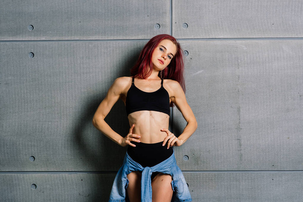 Portré fitness nő a stúdióban cement beton háttér. - Fotó, kép