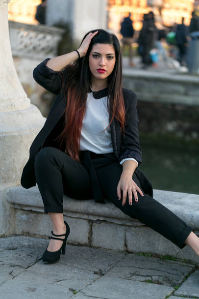 schöne brünette langhaarige Mädchen posiert in Jacke und schwarzer Hose in Padua. Hochwertiges Foto - Foto, Bild