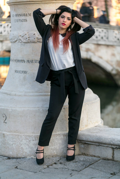 beautiful brunette long haired girl posing in jacket and black pants in padua. High quality photo - Φωτογραφία, εικόνα