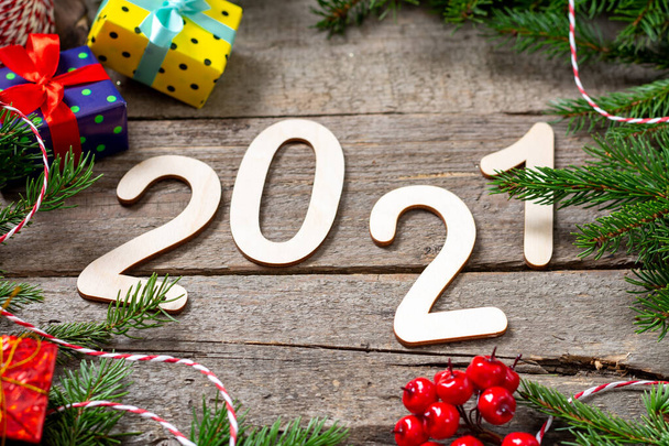 Happy new year 2021. Number 2021 is made of wood on a brown wooden background. Christmas background with fir branches - Foto, Bild