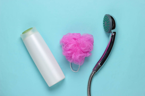 Sprchování. Sprcha hlava s vanou houbou, láhev šamponu na modrém pozadí. Horní pohled - Fotografie, Obrázek