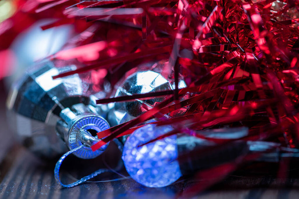 Lesklé balónky, elektrické věnce a pestrobarevné cínové prvky vánoční ozdoby stromků, detailní, selektivní zaměření. Nový rok a Vánoce - Fotografie, Obrázek