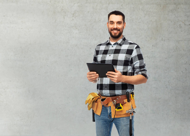 happy builder with tablet computer and tools - Фото, изображение