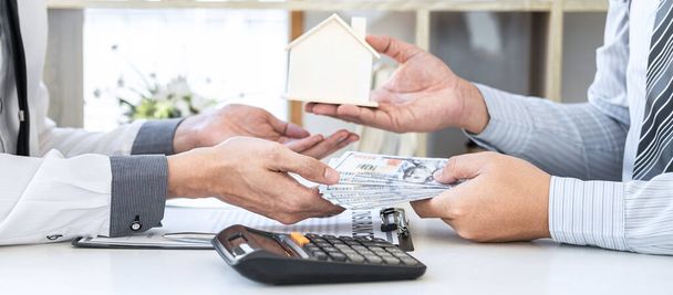 Agent nieruchomości dając dom i klucze do klienta po podpisaniu umowy nieruchomości z zatwierdzonym formularzem wniosku o kredyt hipoteczny, dotyczące oferty kredytu hipotecznego i ubezpieczenia mieszkaniowego. - Zdjęcie, obraz