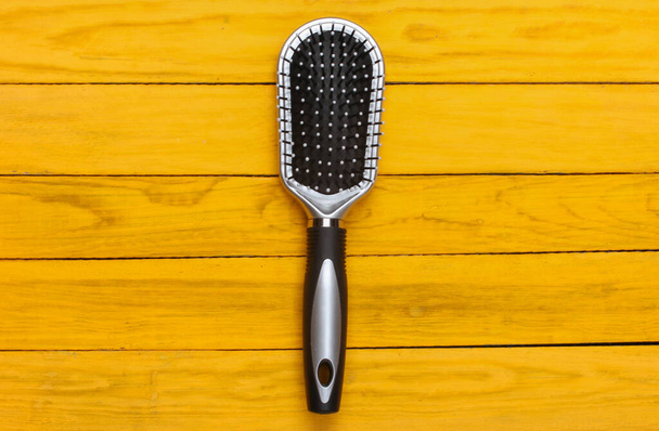 Hairbrush on a yellow wooden background. - 写真・画像