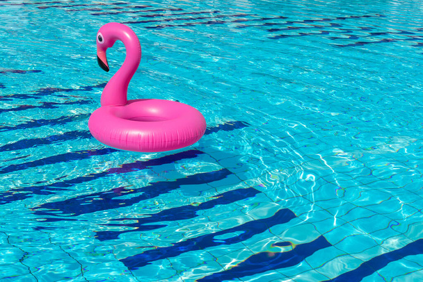 Kesäalennusmyynti Vaaleanpunainen puhallettava flamingo uima-altaassa veden kesärannalla tausta. Minimaalinen kesäkonsepti - Valokuva, kuva