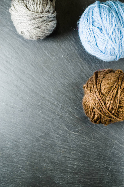 A vertical shot of balls of yarn on a rough surface - copy space - Fotoğraf, Görsel