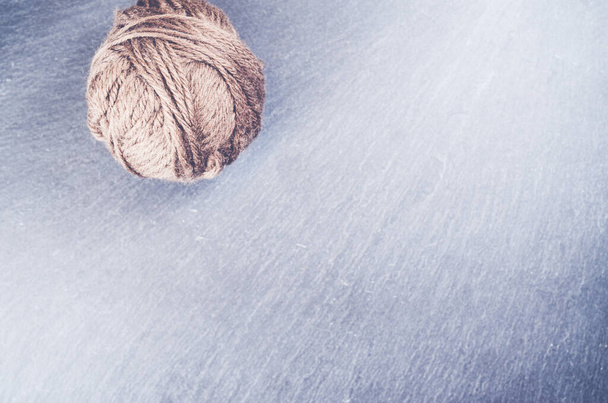 A high angle shot of a ball of yarn on a rough surface - Foto, Bild