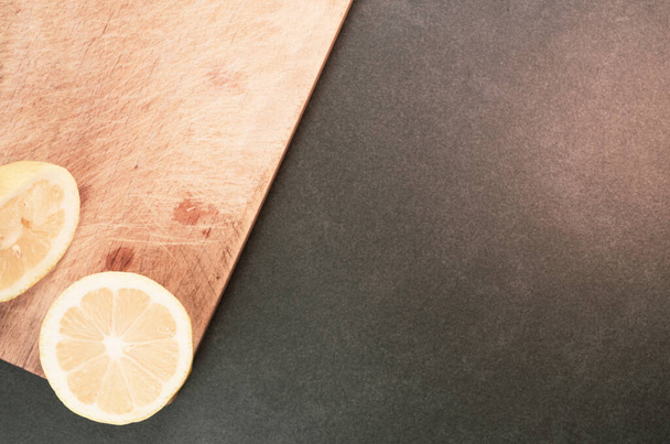 A high angle shot of slices of lemon on a wooden board - Фото, зображення