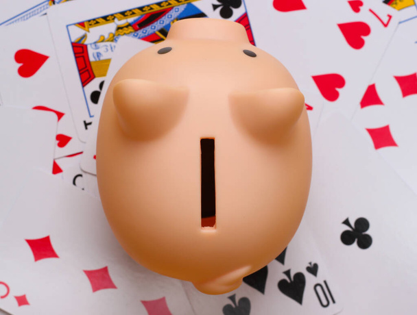 Piggy bank on playing cards. Top view. Game addiction - Photo, Image