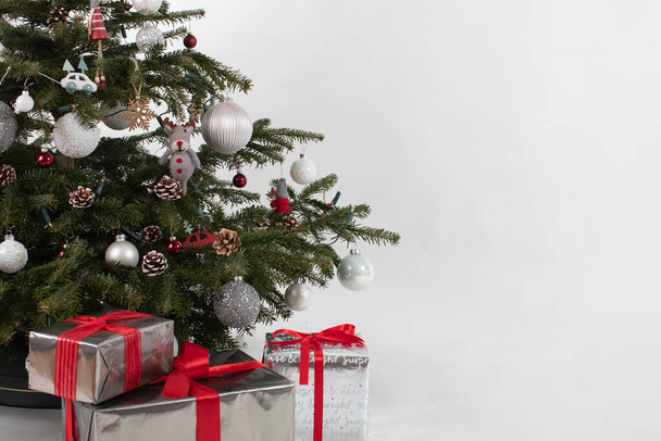 Albero di Natale con tre regali sotto. Decorazione color argento-bianco-rosso - Foto, immagini