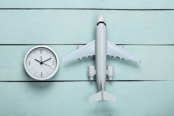 Seyahat zamanı. Mavi ahşap arka planda uçak figürü ve saat. Üst Manzara. Düz yatıyordu - Fotoğraf, Görsel