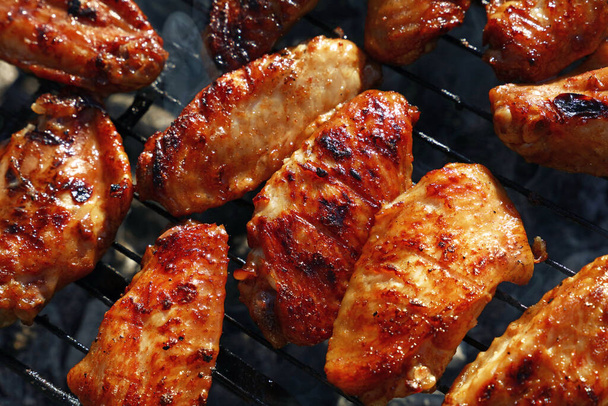 Close up chicken buffalo wings cooked on bbq smoke grill, high angle view - Photo, Image