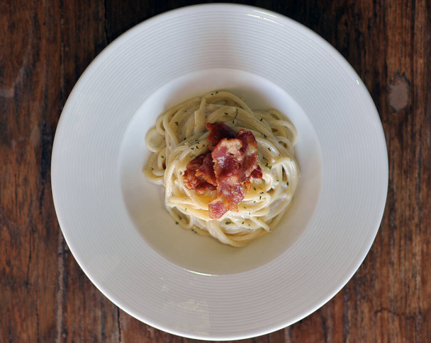 Lahodné špagety carbonara se slaninou na dřevěném stole - Fotografie, Obrázek