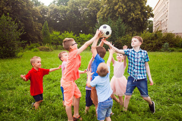 The kids play with a ball in the school garden - Foto, Imagen