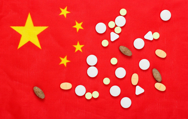 Таблетки с флагом Китая. Пандемический ковид-19 - Фото, изображение