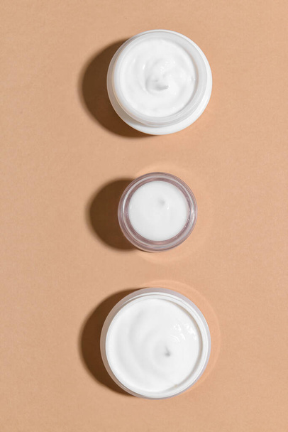 Cosmetische crème potten op kleur achtergrond - Foto, afbeelding