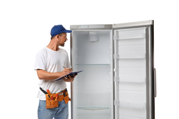 Arbeiter des Reparaturdienstes in der Nähe des Kühlschranks auf weißem Hintergrund - Foto, Bild