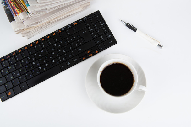pilha de jornais e teclado com xícara de café close-up
 - Foto, Imagem