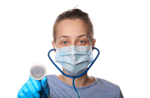 Frau in Schutzmaske, Handschuhe halten ein Stethoskop isoliert auf weißem Hintergrund - Foto, Bild