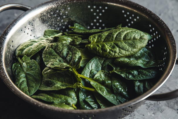 Fresh mini spinach in a colander on the old concrete table. Healthy food, eco product. Vegan - Fotoğraf, Görsel