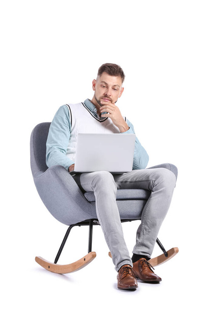 Αρσενικός ψυχολόγος με φορητό υπολογιστή κάθεται στην πολυθρόνα σε λευκό φόντο - Φωτογραφία, εικόνα