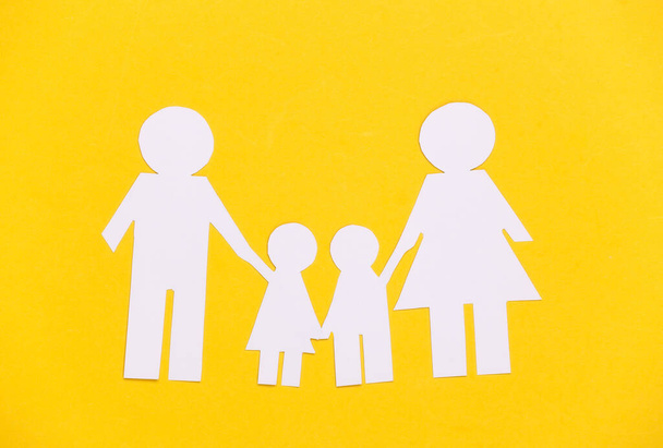 Papier gelukkige familie samen op gele achtergrond. - Foto, afbeelding