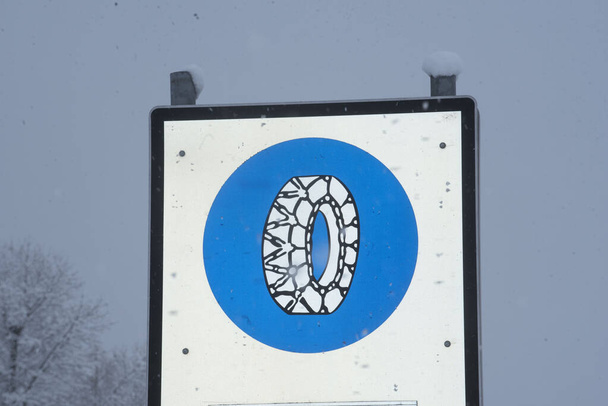 снежная цепь обязана дорожным знаком в горах в зимний период - Фото, изображение