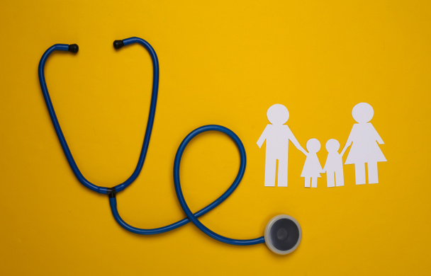 Famille stéthoscope et chaîne de papier sur fond jaune, concept d'assurance maladie - Photo, image