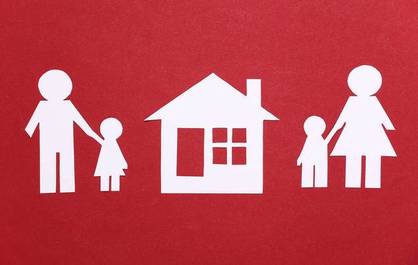 Broken family, divorce. Property division. Split paper family, house on a red background - Foto, imagen