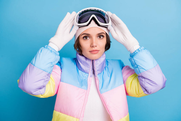 Photo of beautiful skier woman hold goggles mask extreme hobby winter season isolated on blue color background - Photo, Image