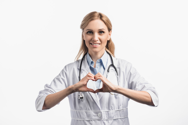 glücklich Krankenschwester im weißen Mantel lächelt, während sie hört Zeichen mit Händen isoliert auf weiß - Foto, Bild