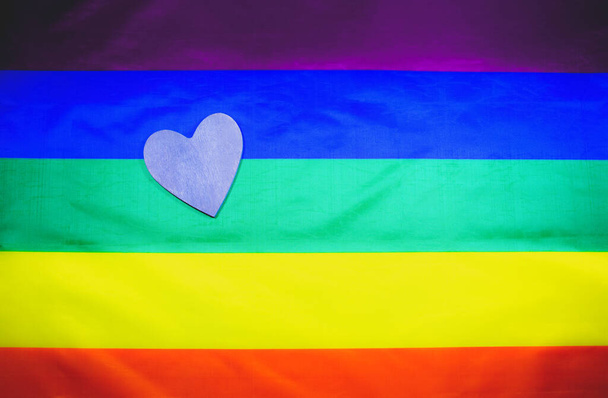 A közösség színes zászlója. Fa szív szivárvány háttér. Leszbikus és meleg problémák. A házasság legalizálása homoszexuális beállítottságú párok számára. Nemek közötti egyenlőség. - Fotó, kép