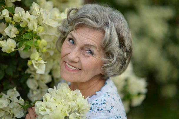 Older woman with white flowers - Foto, Imagem