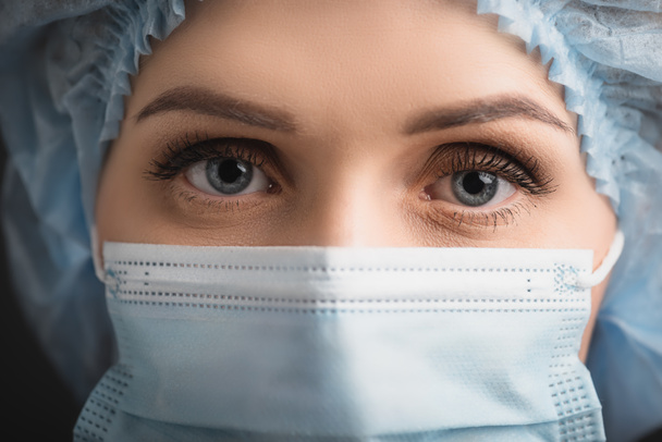 close up of nurse in medical cap and mask looking at camera  - Φωτογραφία, εικόνα