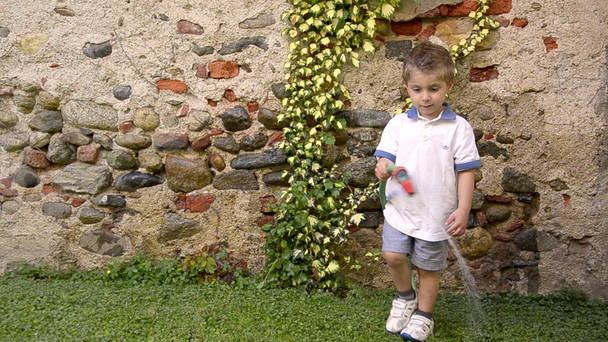 Uma criança engraçada regando o jardim
 - Filmagem, Vídeo