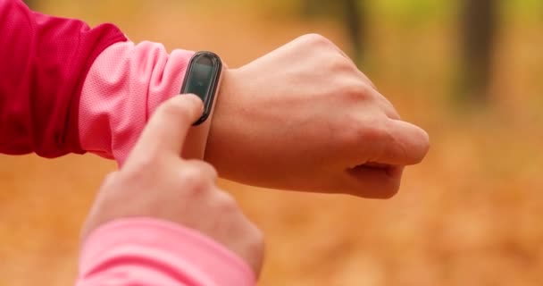fitness woman using fitness tracker for marathon and fitness. Hand measures the pulse using an electronic device - Footage, Video