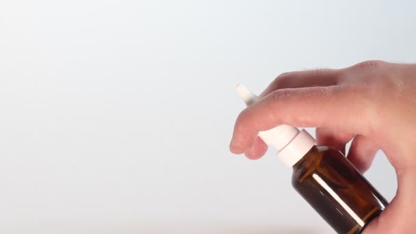 Mens hand sprays Nasal Spray from a glass dispenser - Footage, Video