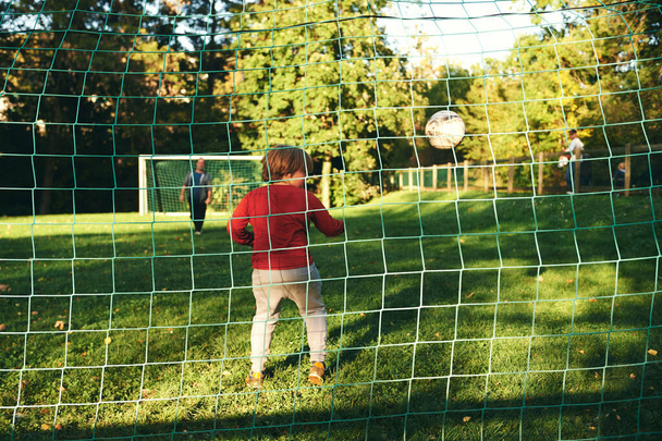 Little boy playing football with his father, kid goalkeeper defending the goal - Foto, Bild